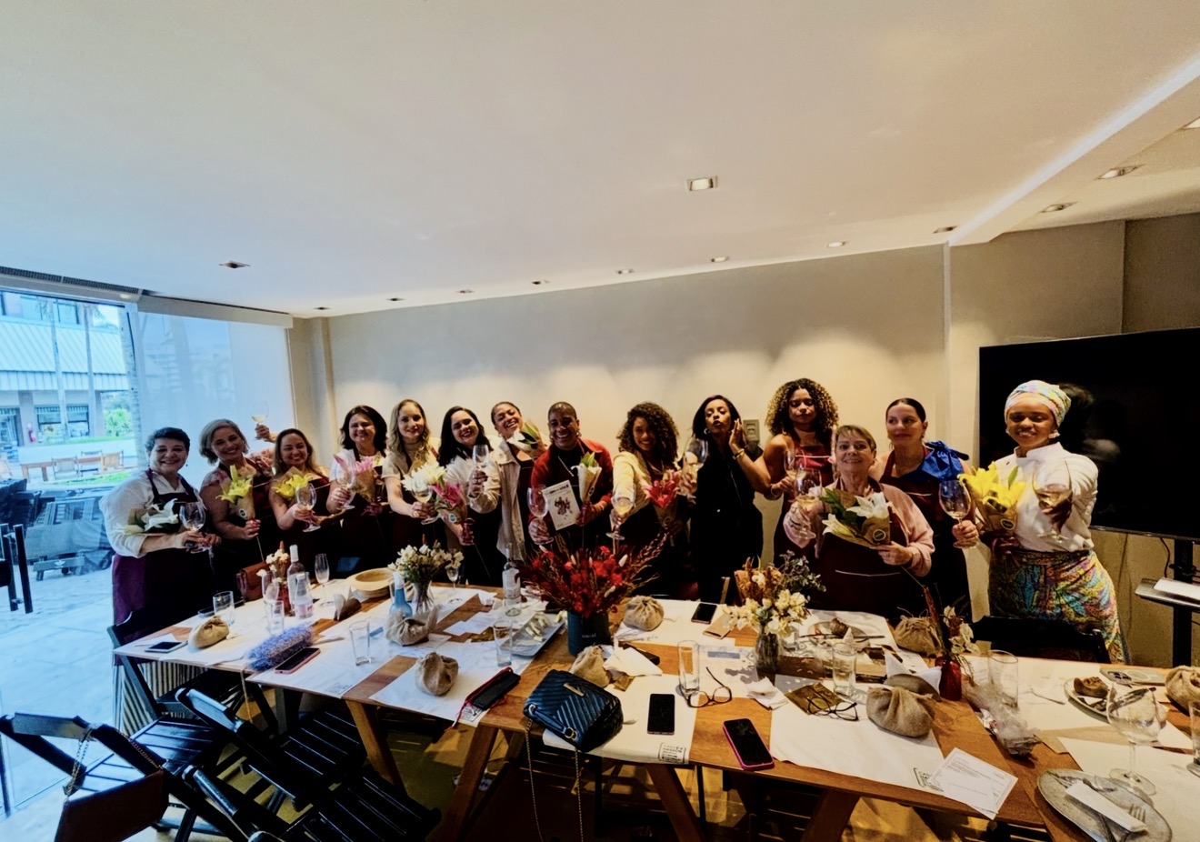 Mesa elegante com mulheres conversando, vinho e gastronomia em luz natural